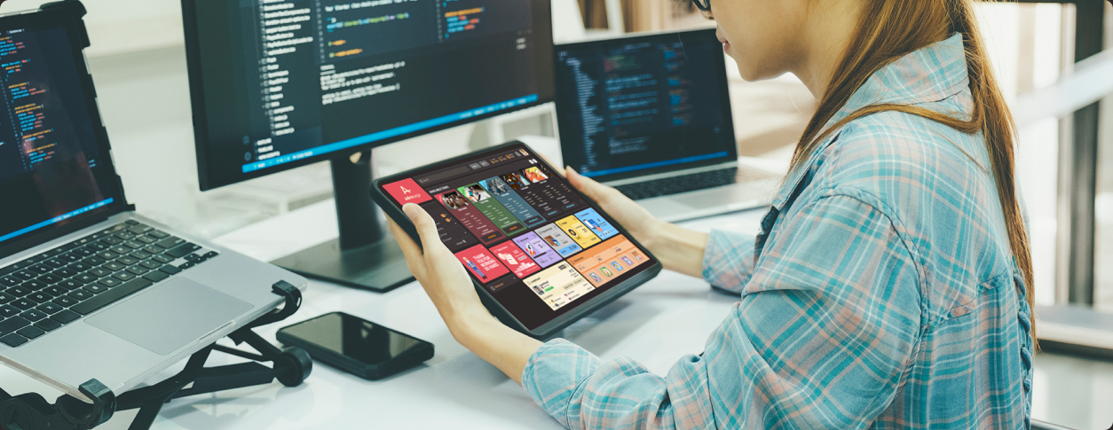 A validator reviewing Adrosaga tasks on a tablet beside a developer workstation
